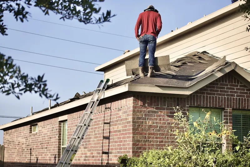 Professional roofer working on a residential roof in East Linden